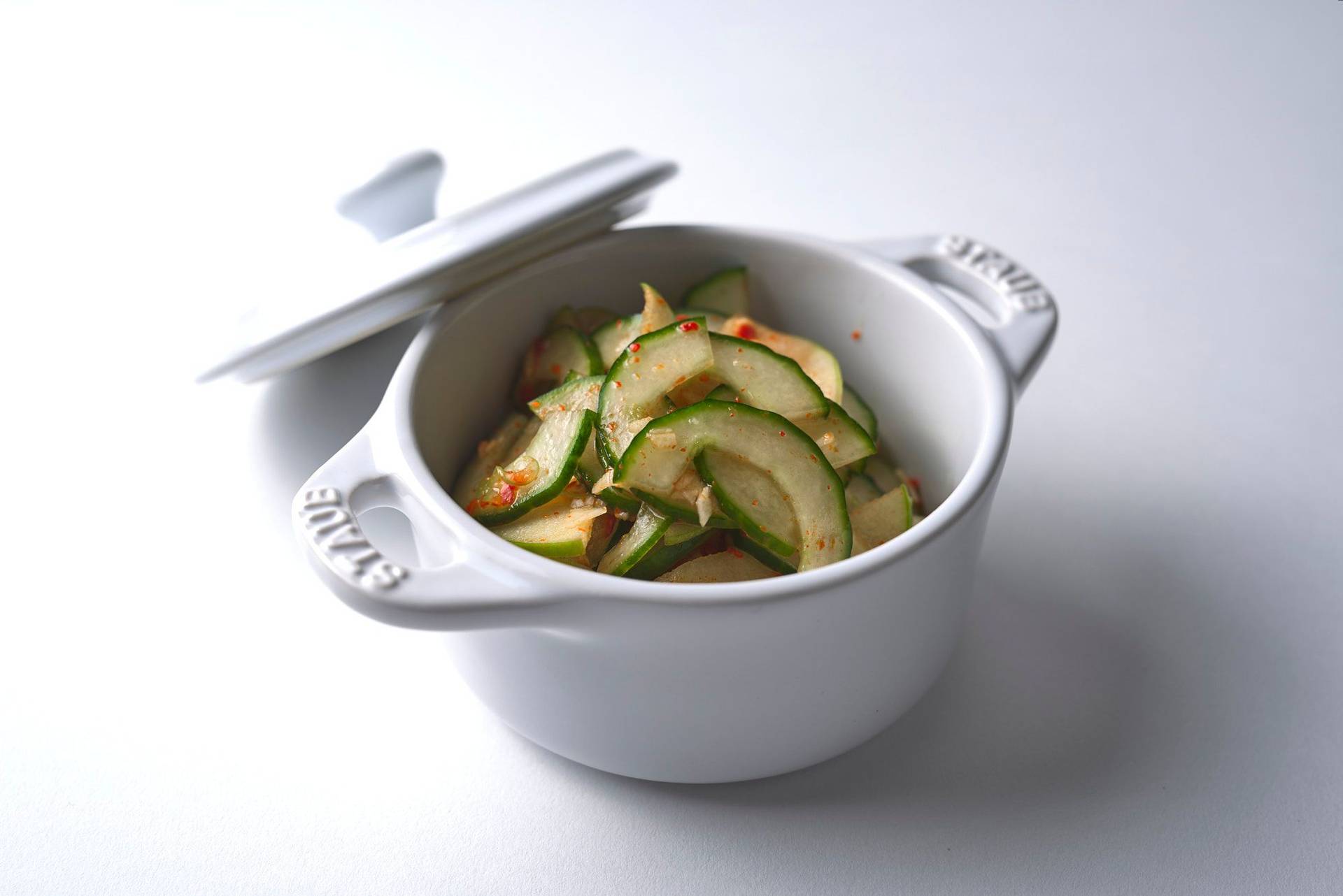fast cucumber kimchi in a white staub pot with white background