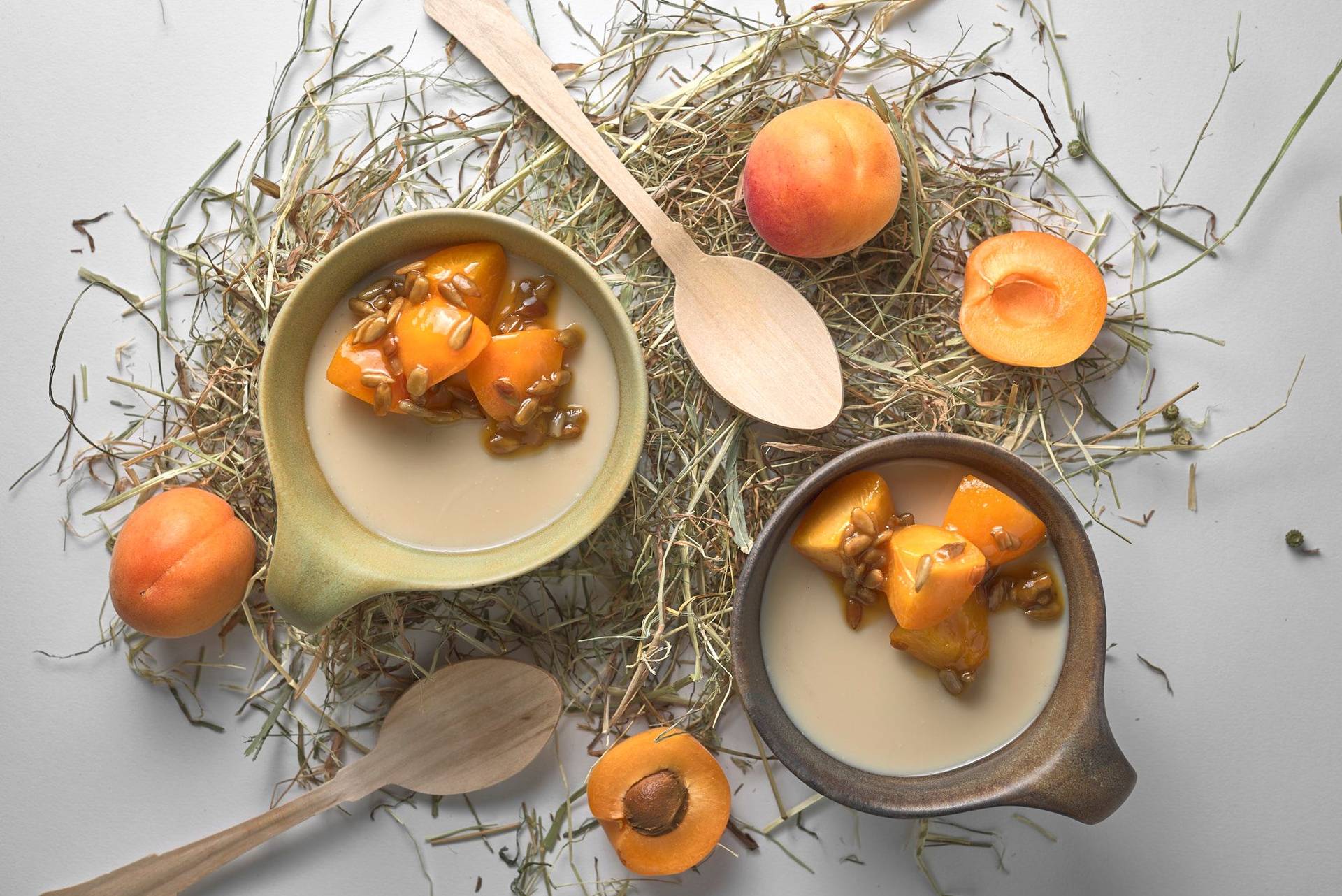 heu panna cotta mit karamellisierten aprikosen und sonnenblumenkernen auf weißem hintergrund