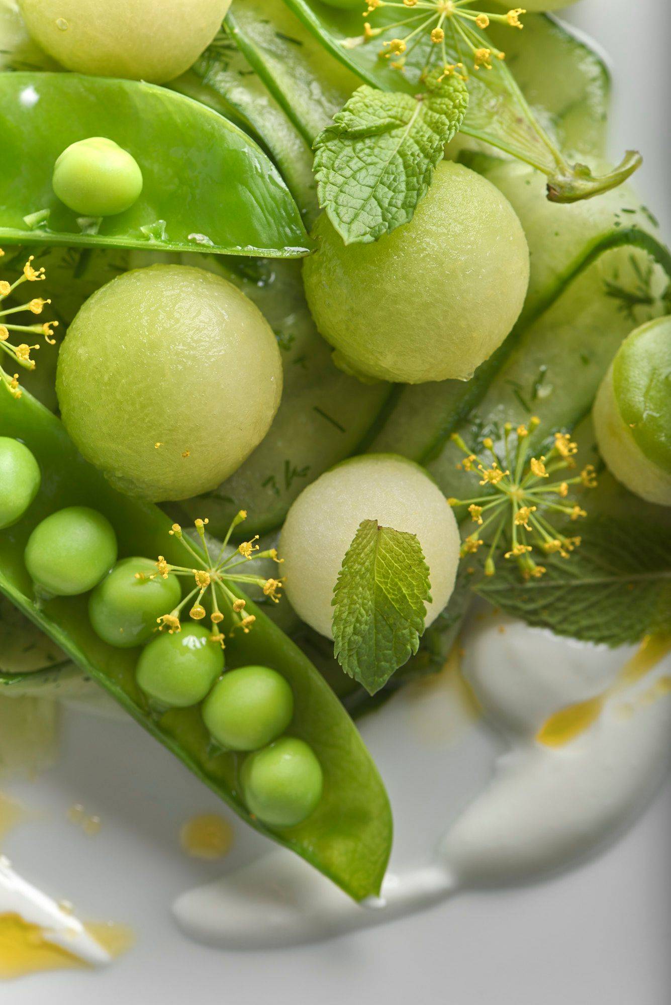 fruchtiger gurkensalat mit melone und leinöl auf einem weißen teller mit marmoriertem sapienstone top