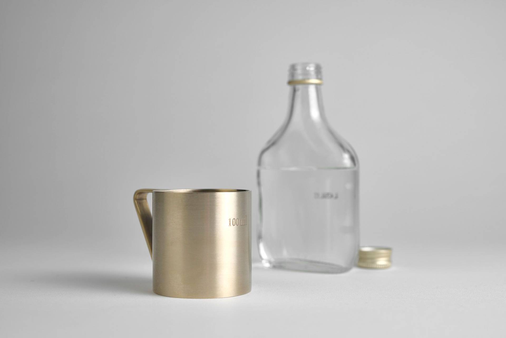 brass measuring cup by danish ferm living on white background