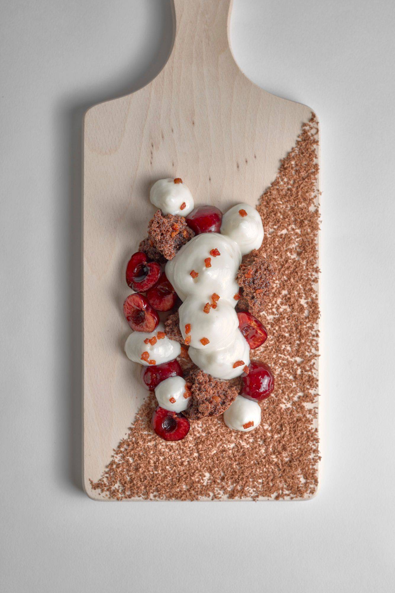 ayran black forest cake dessert with bacon on a wooden board with white background