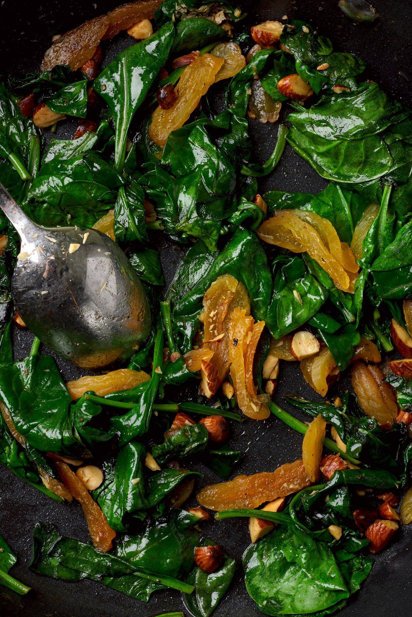 sauteed spinach with apricots and smoked almonds in a pan