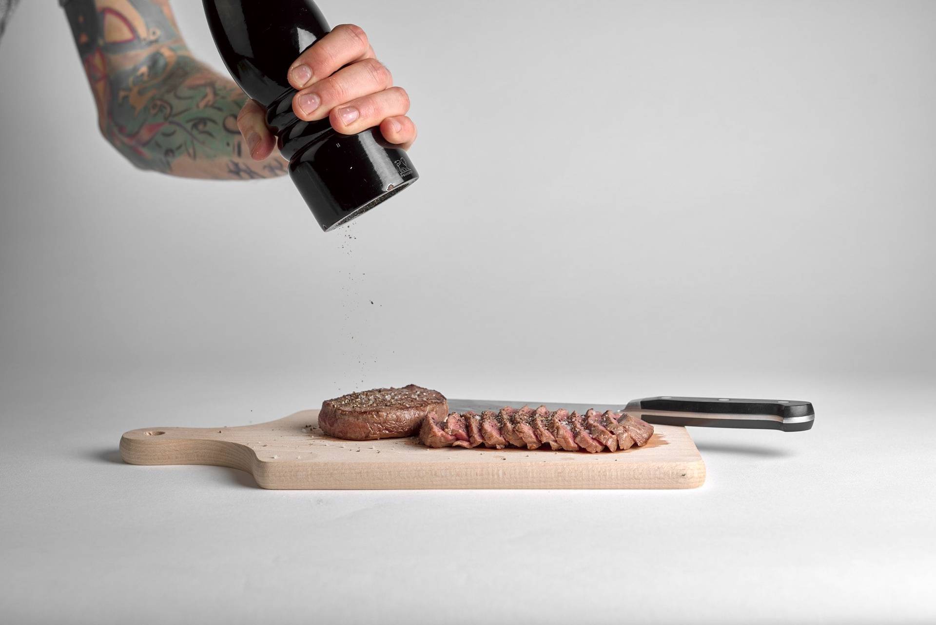 fresh grilled beef tataki on a wooden board with white background