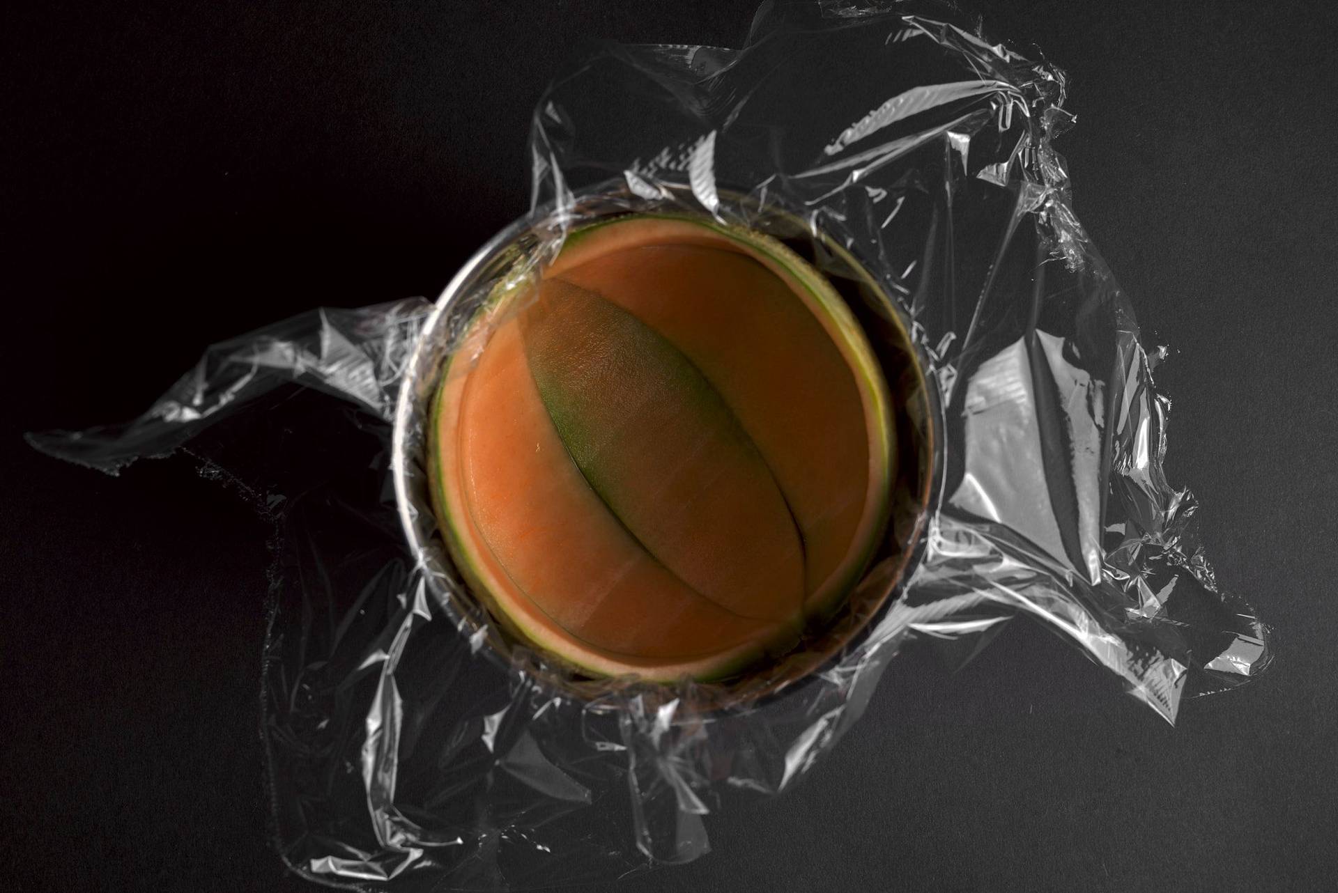 cantaloupe melon peel in a bowl to fill up with melon sorbet on black background