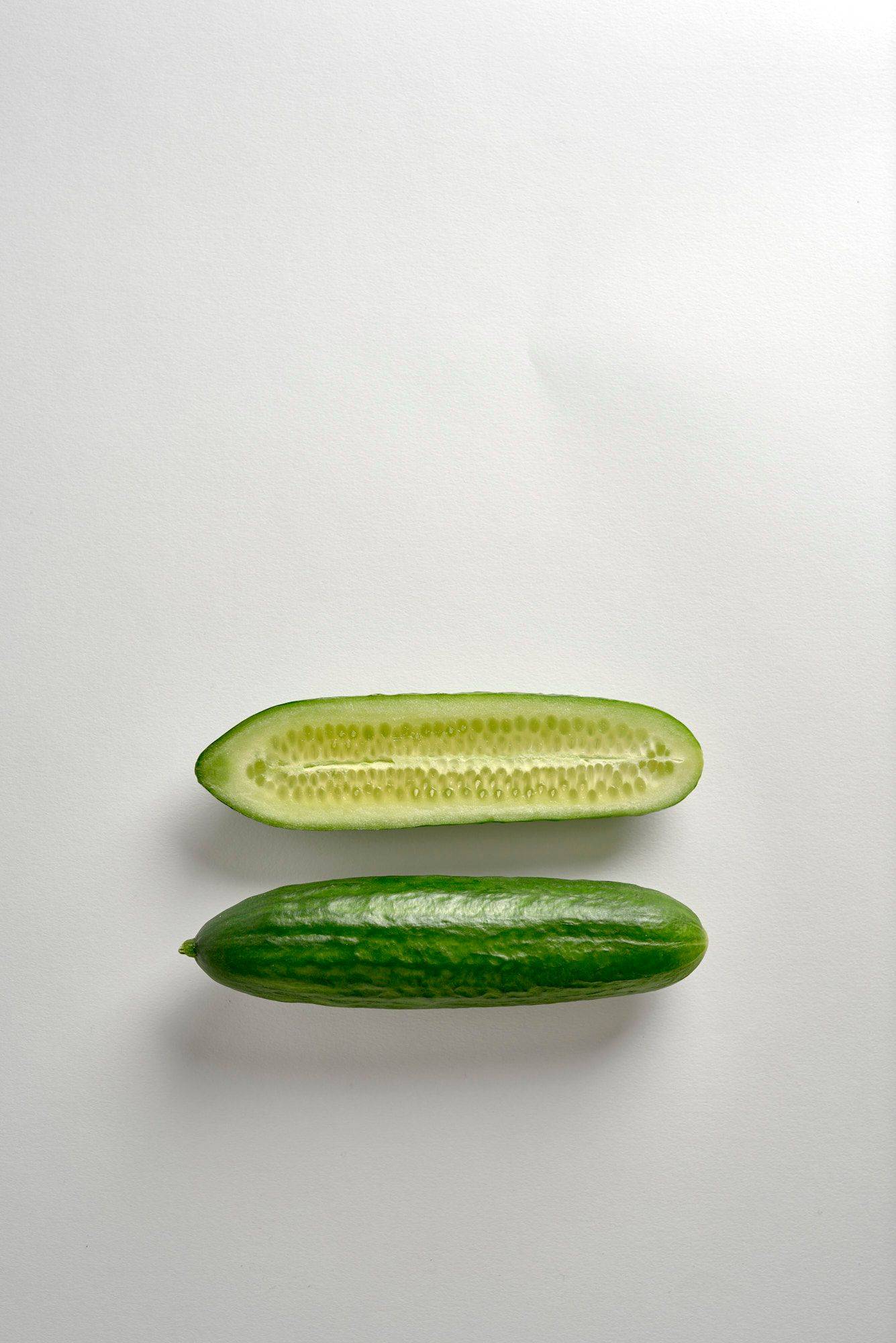 two mini cucumbers on white background