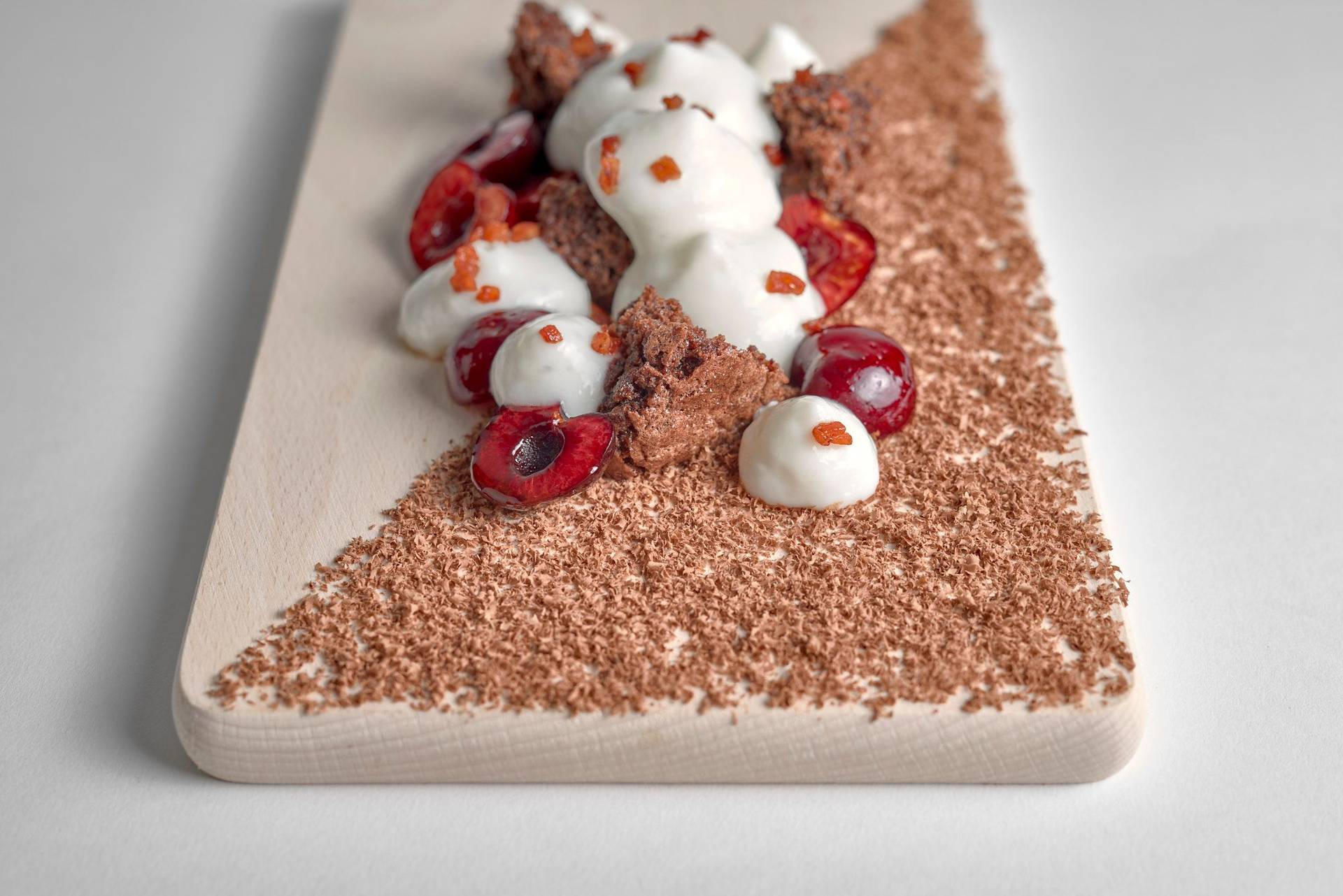 ayran-schwarzwaelder-torte-mit-kirschen-und-speck ayran schwarzwälder torte mit kirschen und speck auf einem holzbrett mit weißem hintergrund