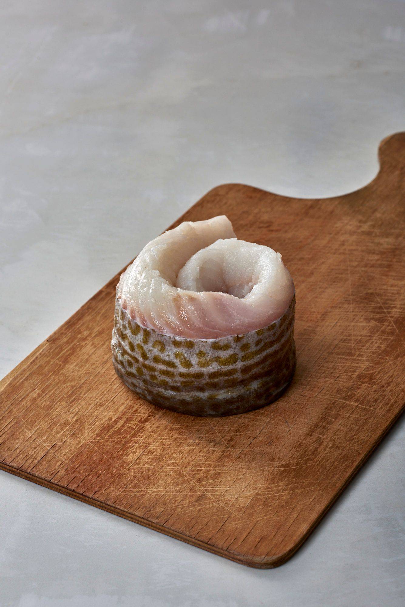 cod fish fillet on a wooden board with white sapienstone top