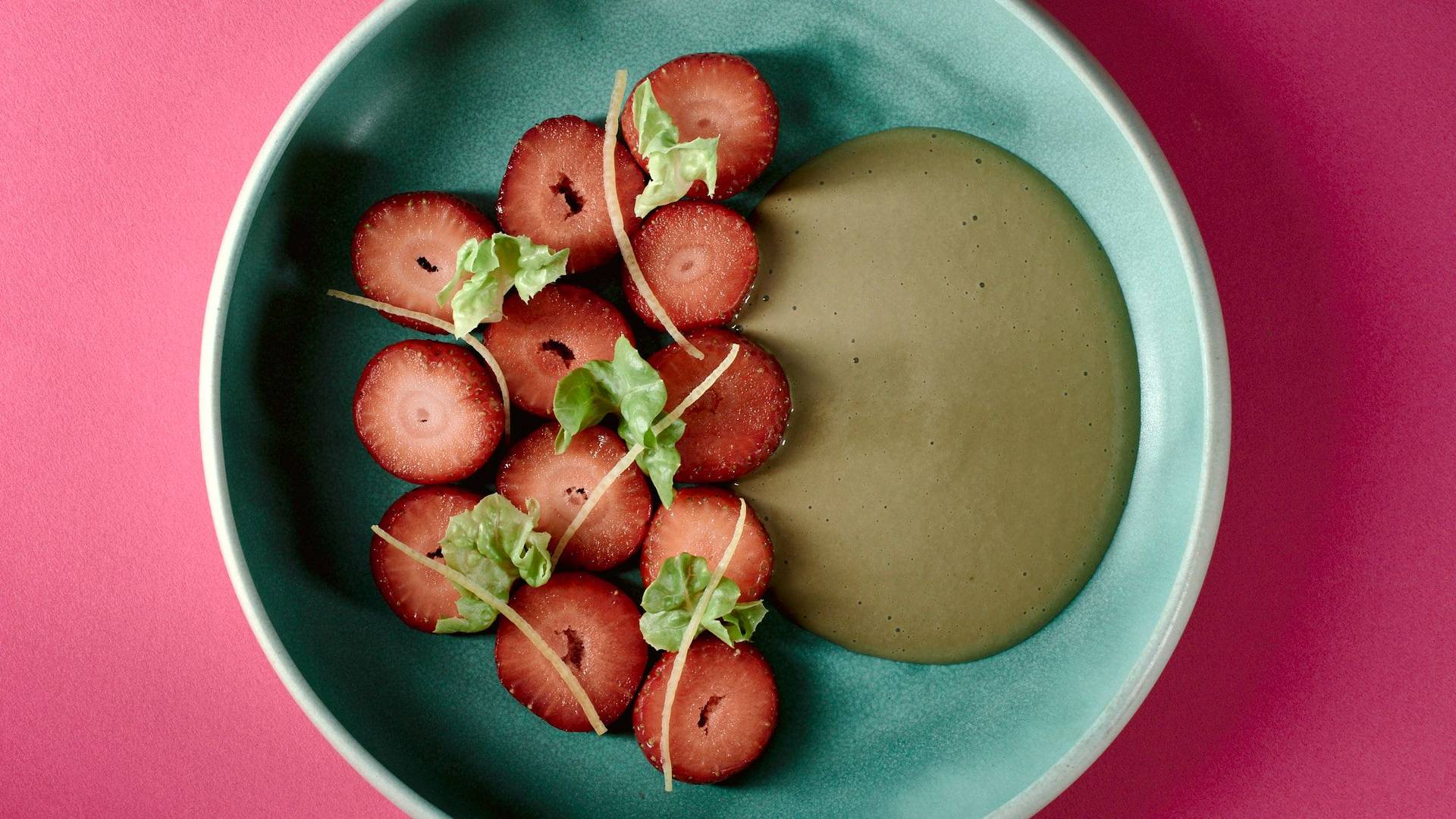 veganes-erdbeerdessert-mit-kopfsalat-und-sonnenblumenkernen veganes erdbeerdessert mit kopfsalat und sonnenblumenkernen auf einem türkisen teller mit pinkem hintergrund