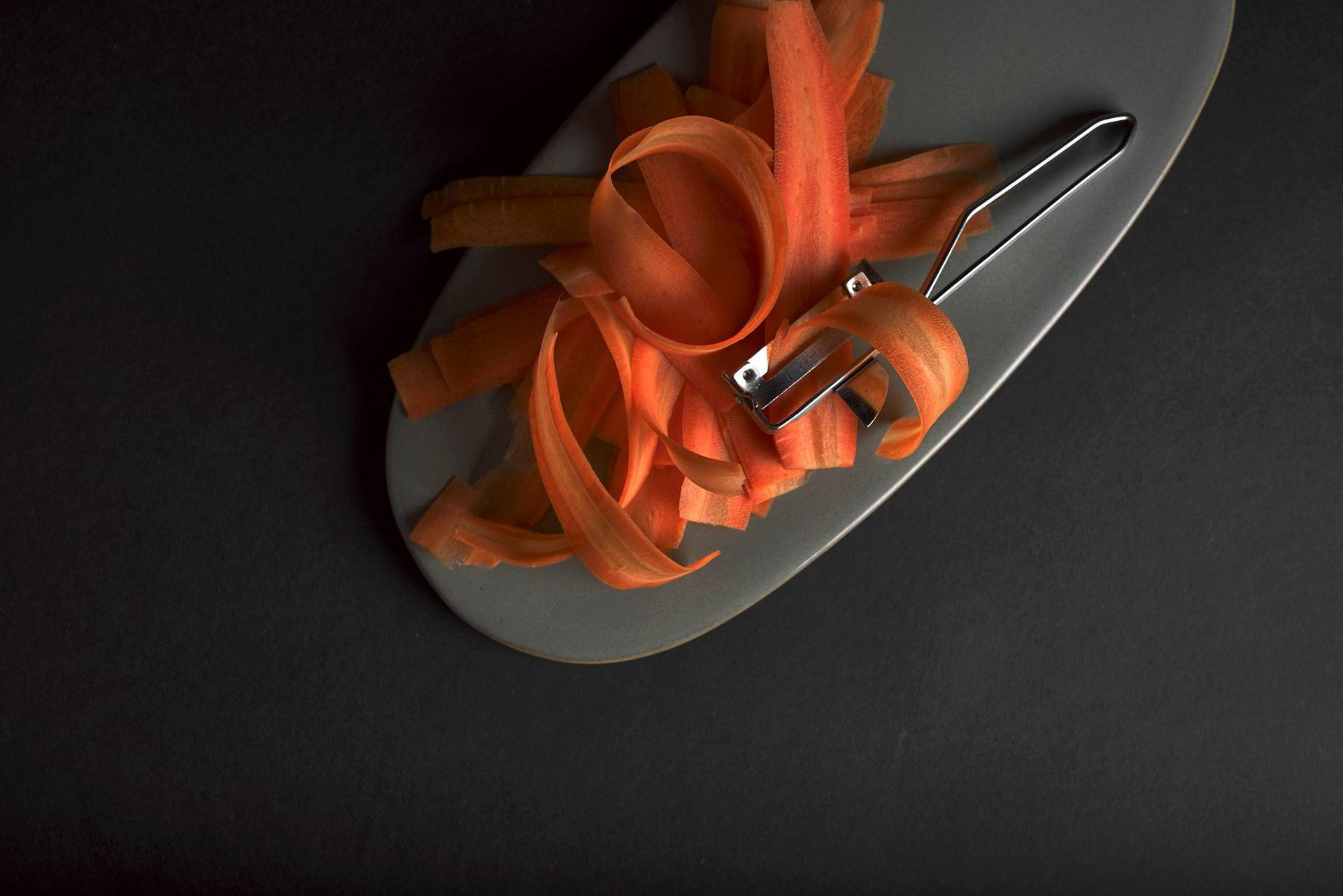 carrot swirls on a gray plate on black background