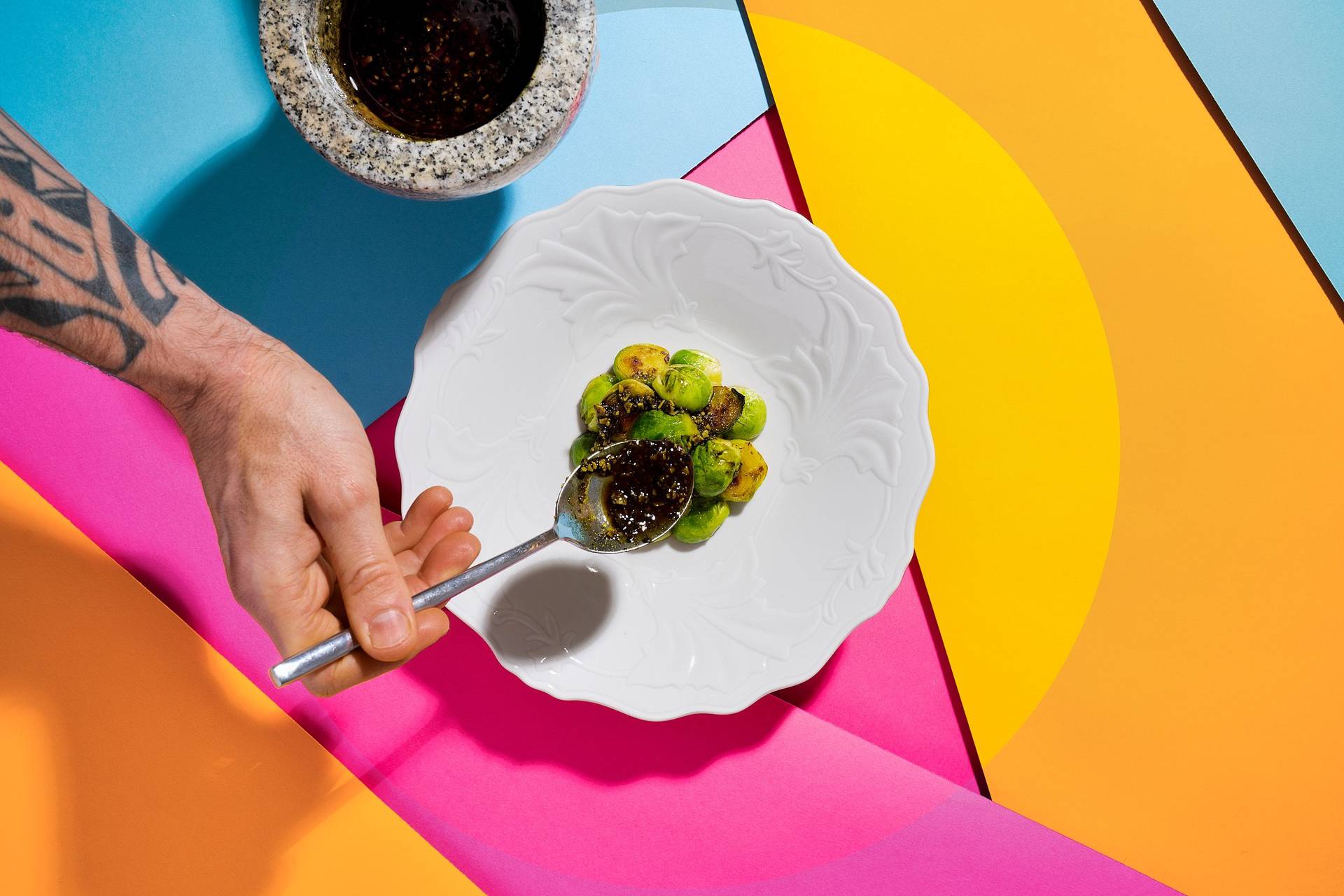 plating roasted brussels sprouts with verjus-pumpkin seed vinaigrette on colorful underground 