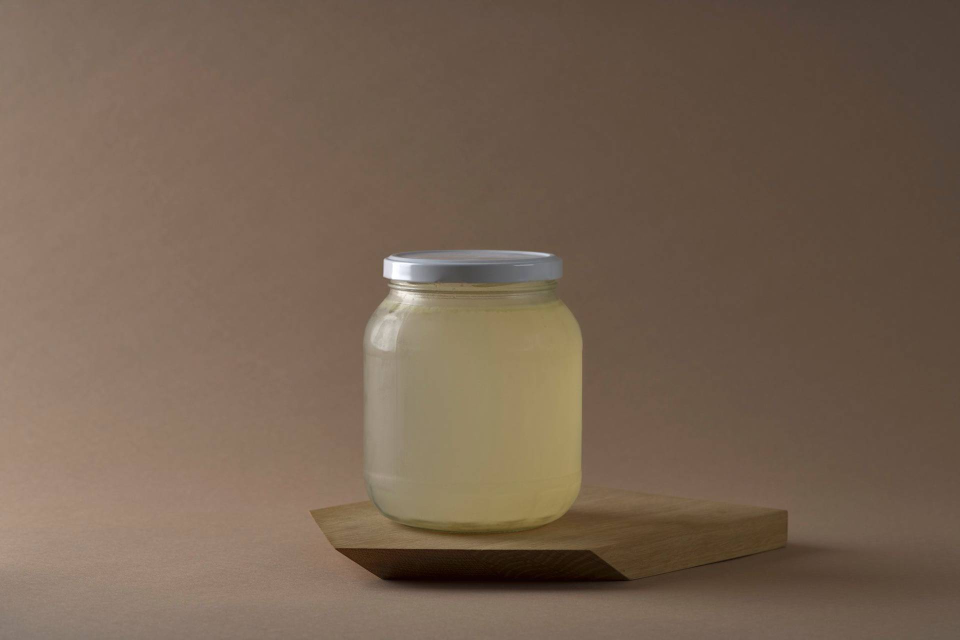 a jar with asparagus stock with brown background