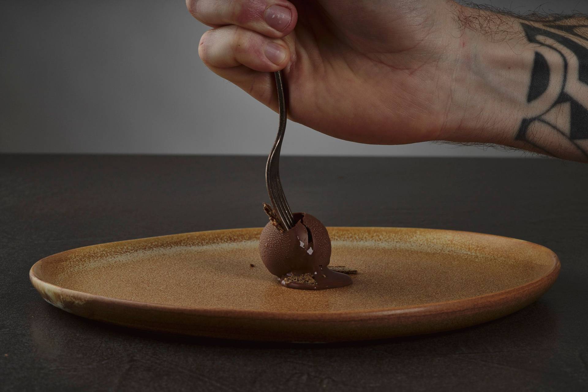 chocolate & rye truffle praline on a brown ceramic plate with gray sapienstone top