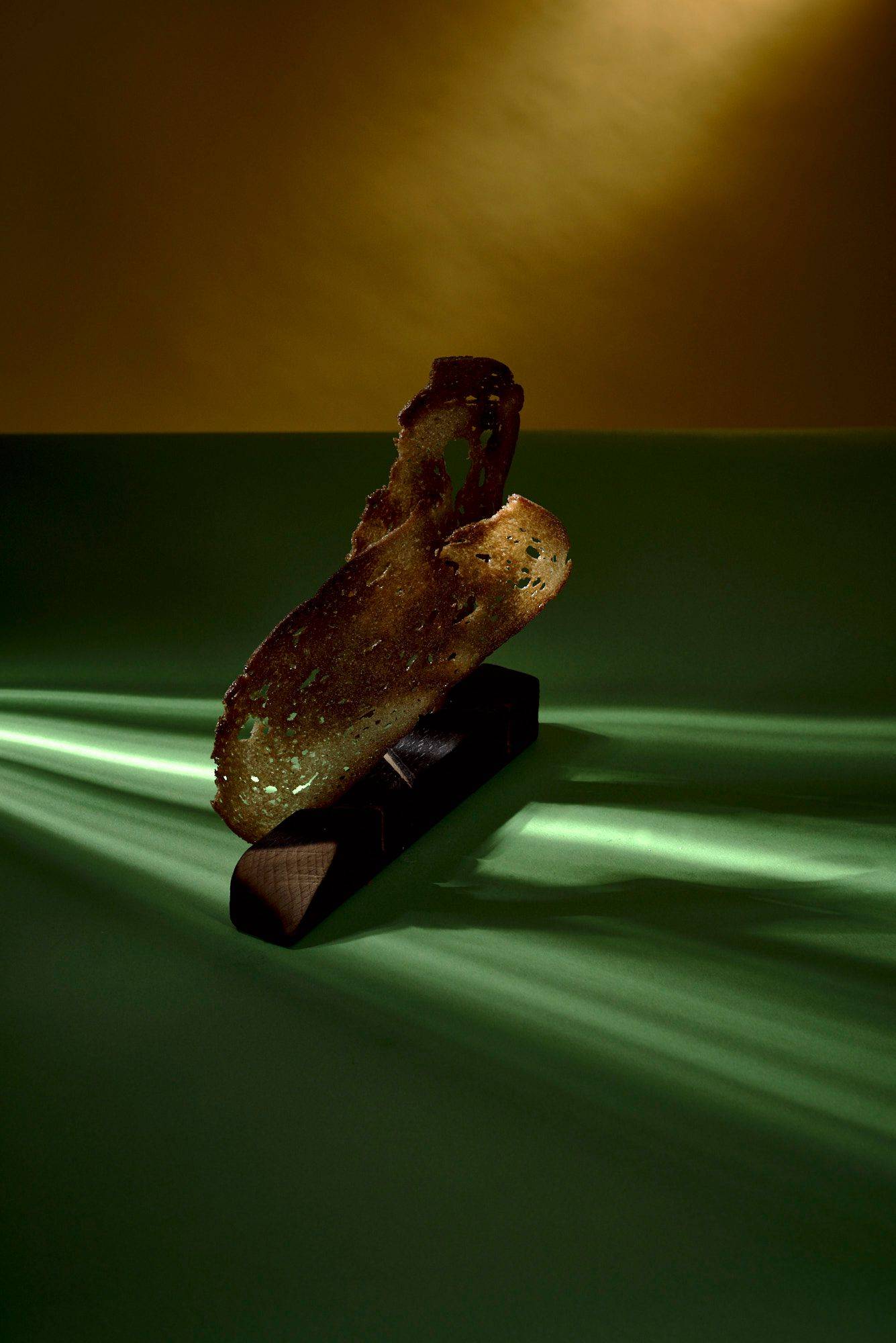 sourdough bread crisps on a wooden stand with green yellow background
