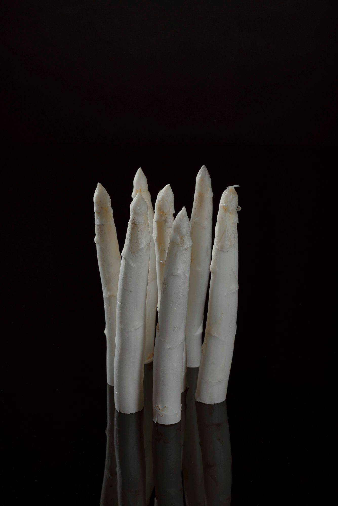 weisser-spargel weißer spargel mit schwarzem hintergrund