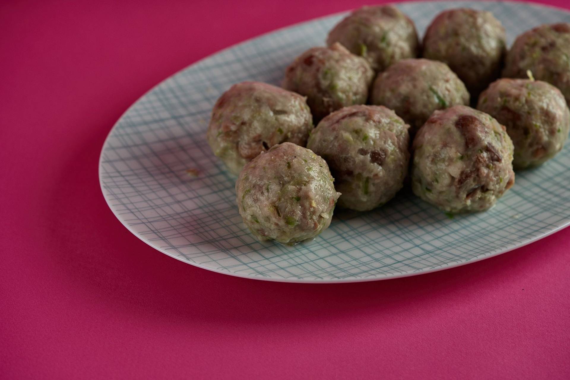 vegane semmelknödel mit rosenkohl vor pink hintergrund