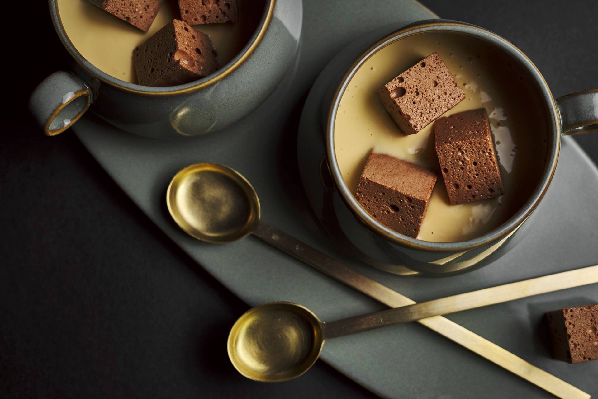 homemade eggnog with chocolate marshmallows on a gray plate with black background