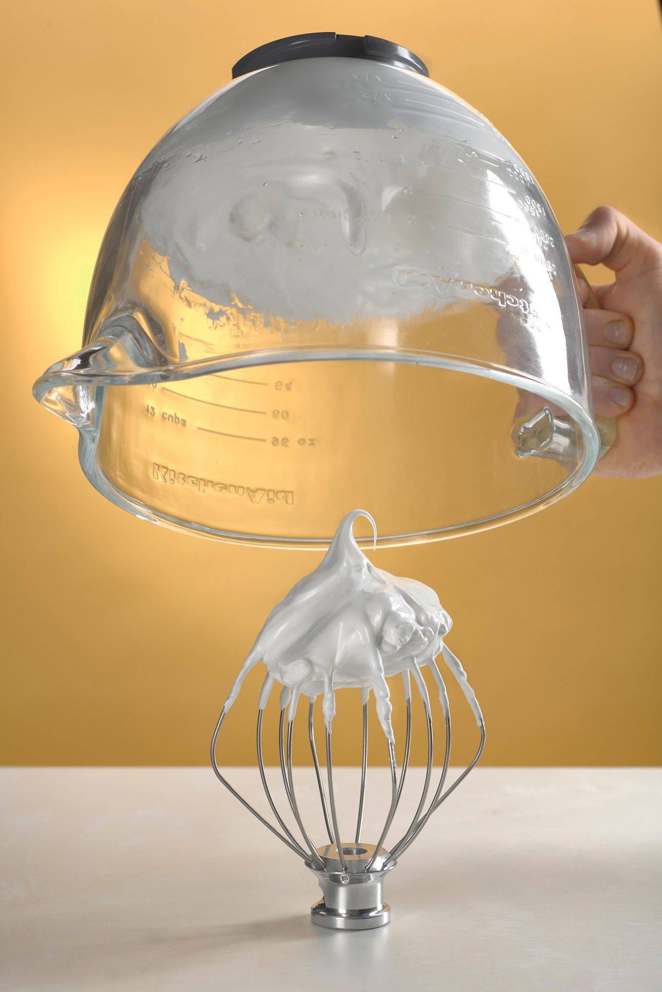 meringue in a glass bowl on white sapienstone top with yellow background