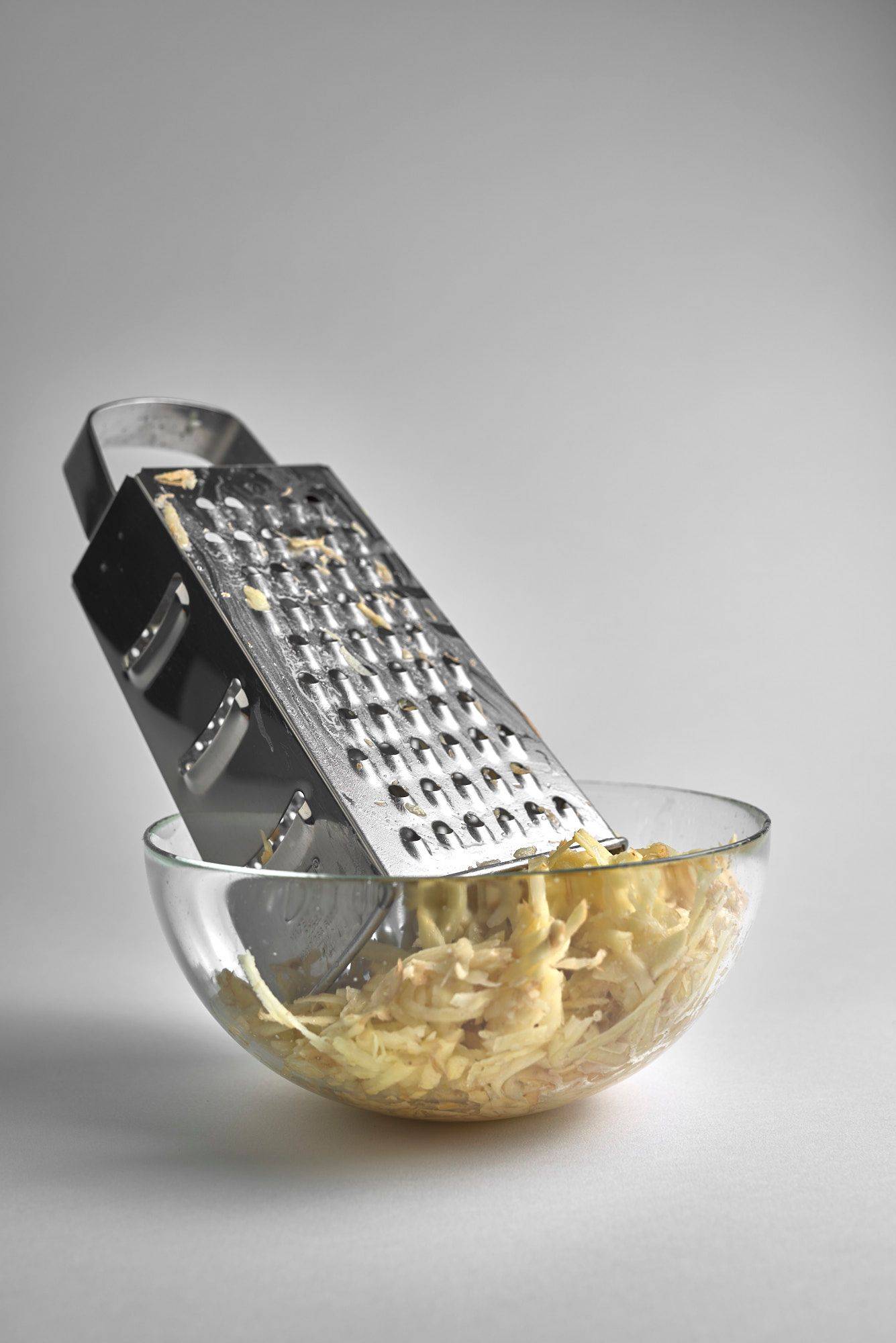 ground potatoes in a glass bowl on white background