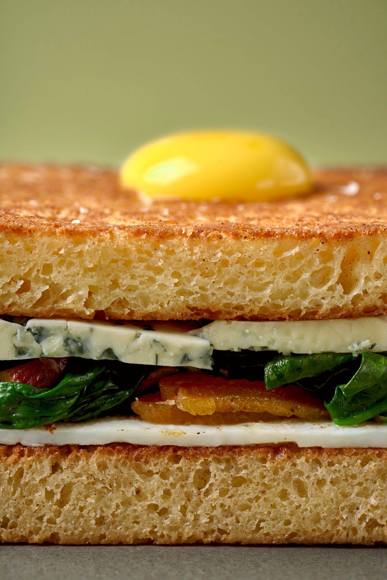 easter bread sandwich on a gray plate with green background