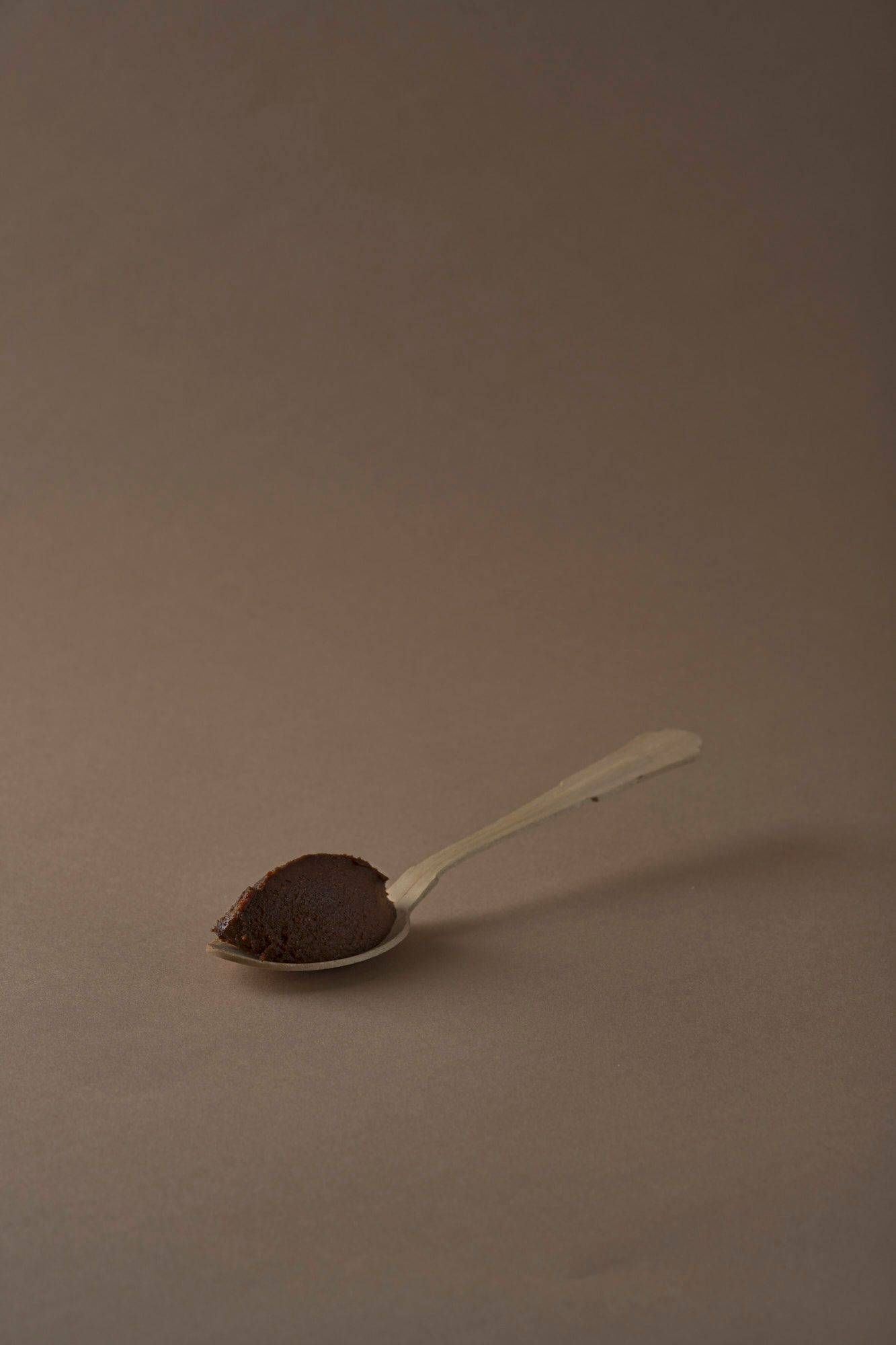 miso-paste miso paste on a wooden spoon with brown background