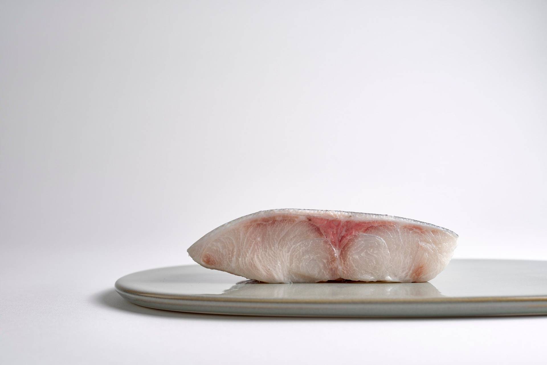 kingfish on a gray plate with white background