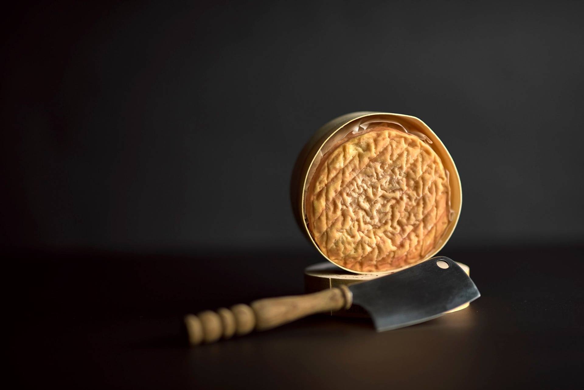 a loaf of epoisse cheese on black background