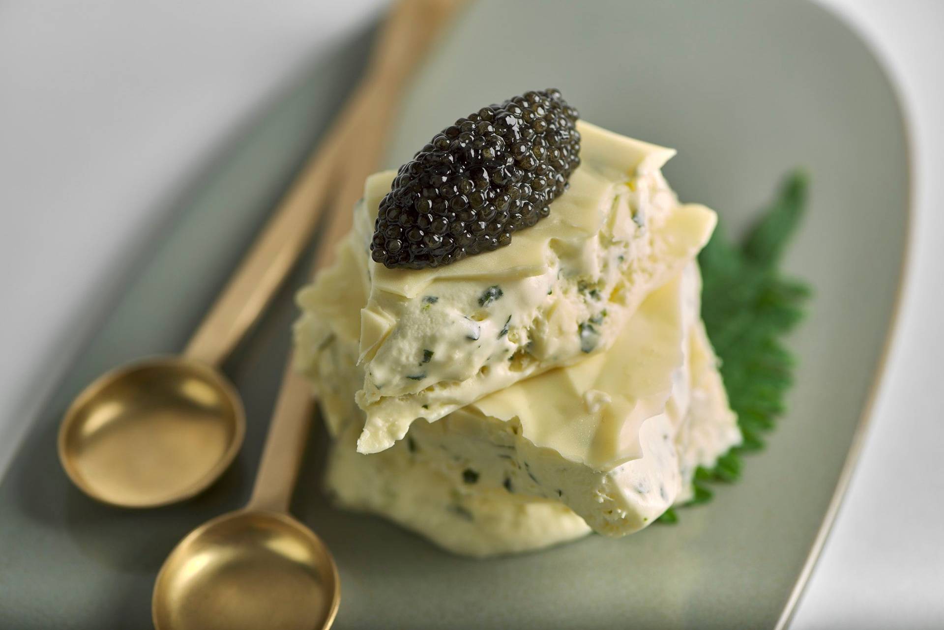 shiso and lime ice cream sandwich with caviar and white chocolate on a gray plate with white background