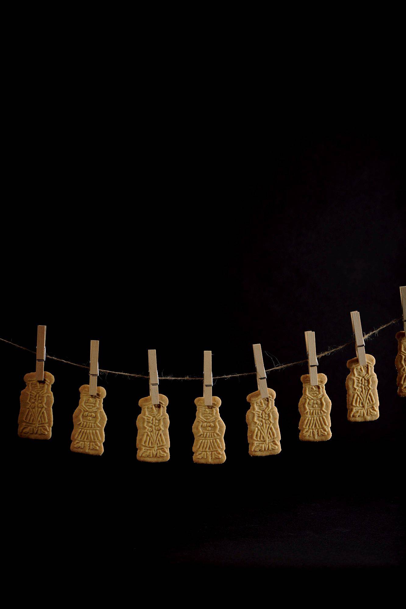 speculoos-cookies speculoos cookies hanging on a string with black background