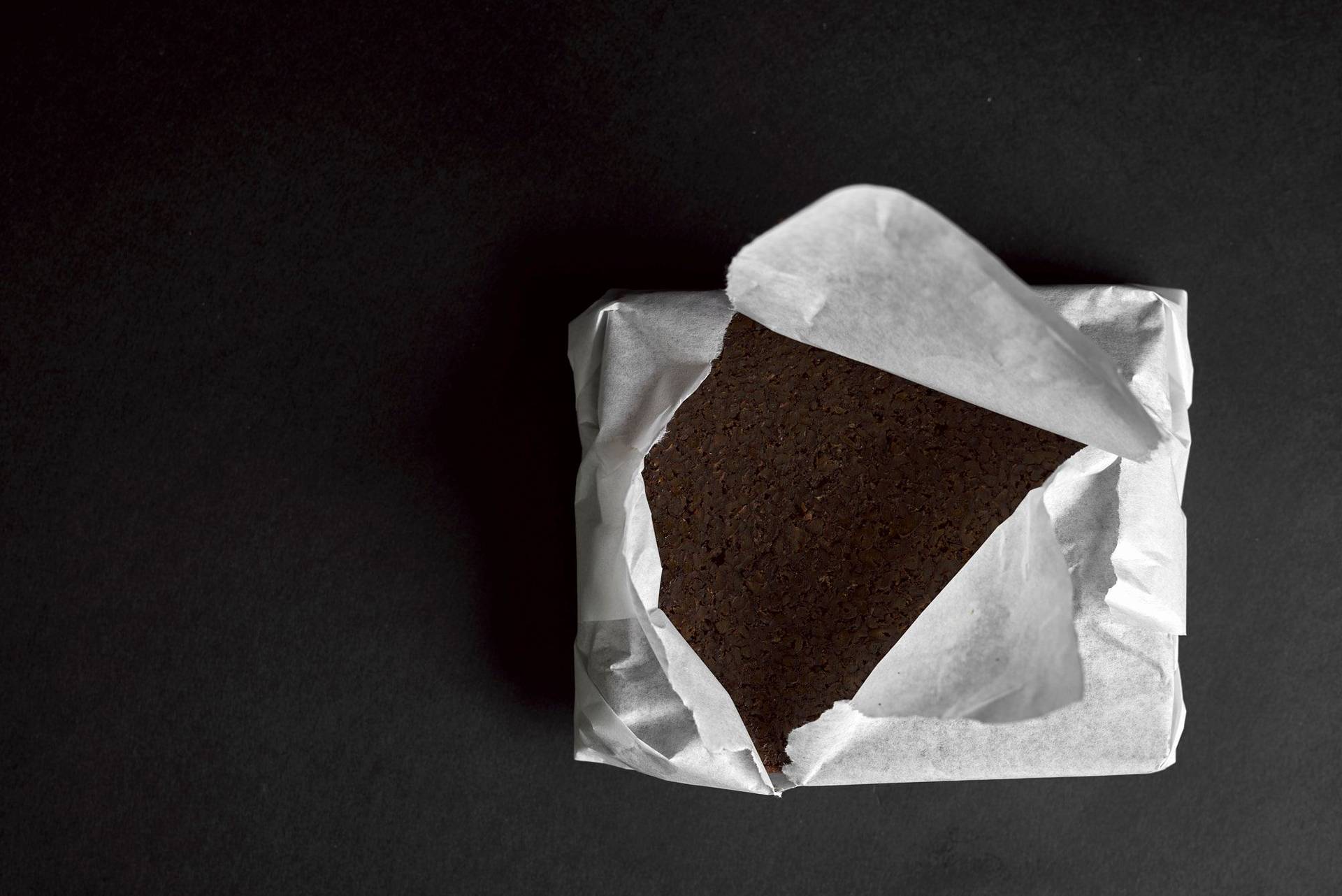 pumpernickel bread wrapped in paper with black background