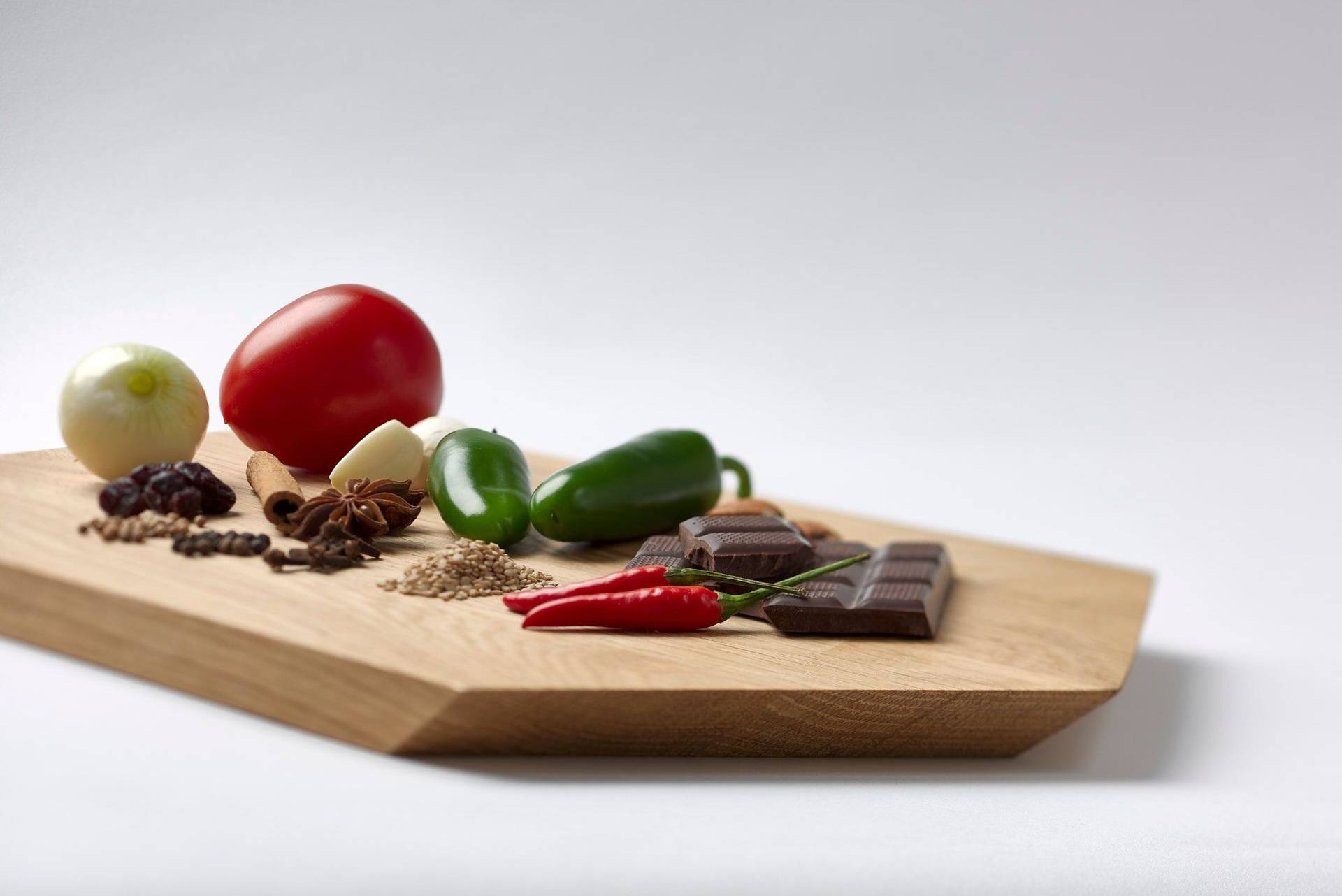 mole sauce ingredients on a wooden board with white background