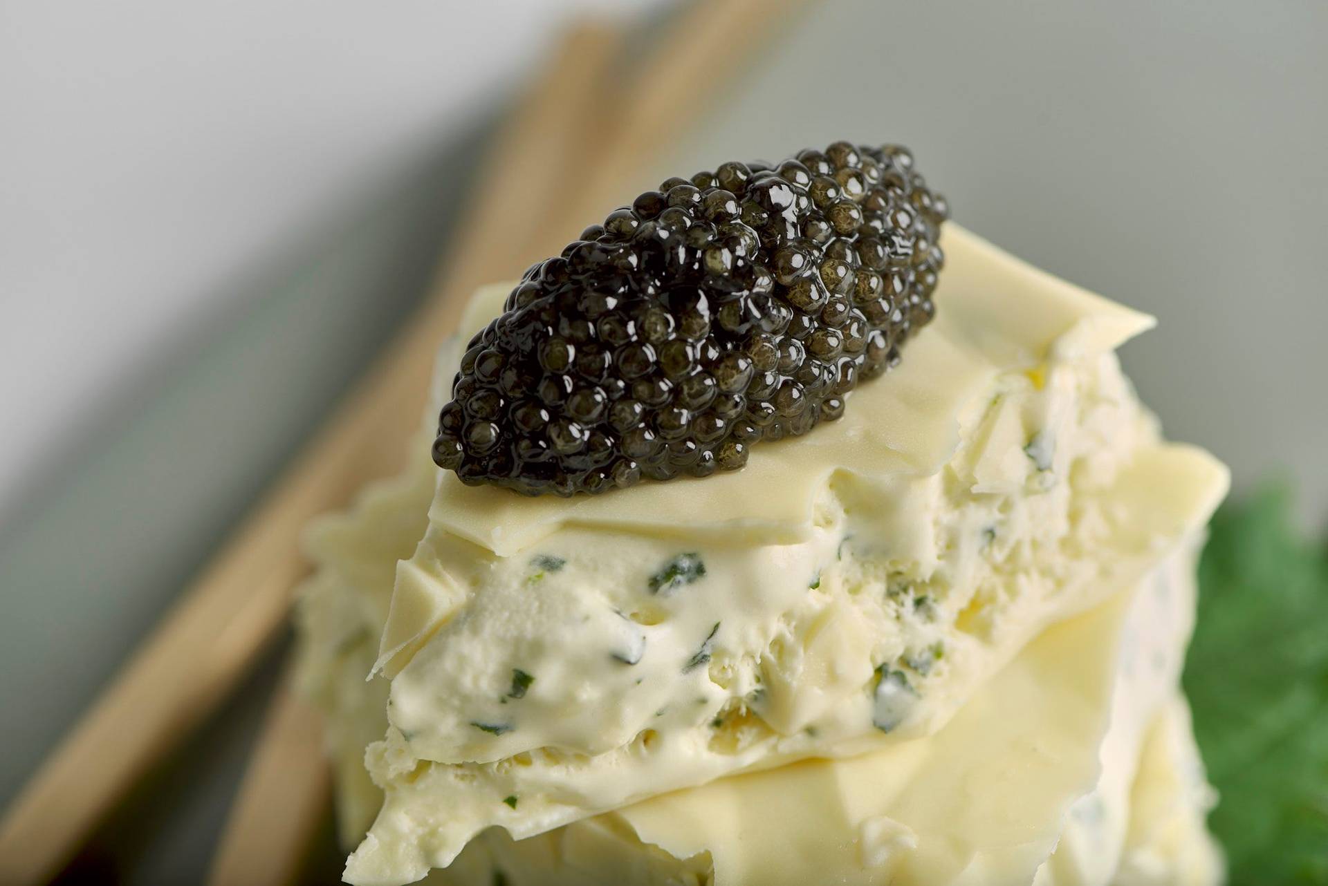 shiso and lime ice cream sandwich with caviar and white chocolate on a gray plate with white background