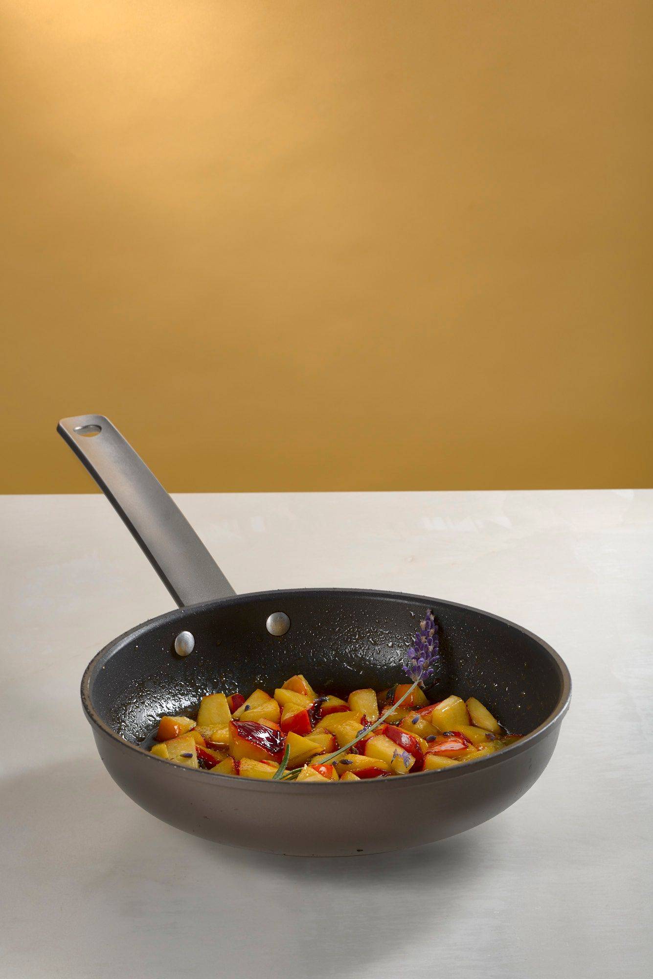 lavender nectarines in a pan on white sapienstone top with yellow background