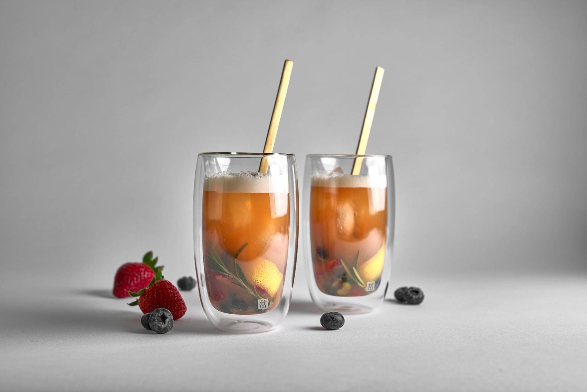 two berlin tea time cocktails with berries on white background