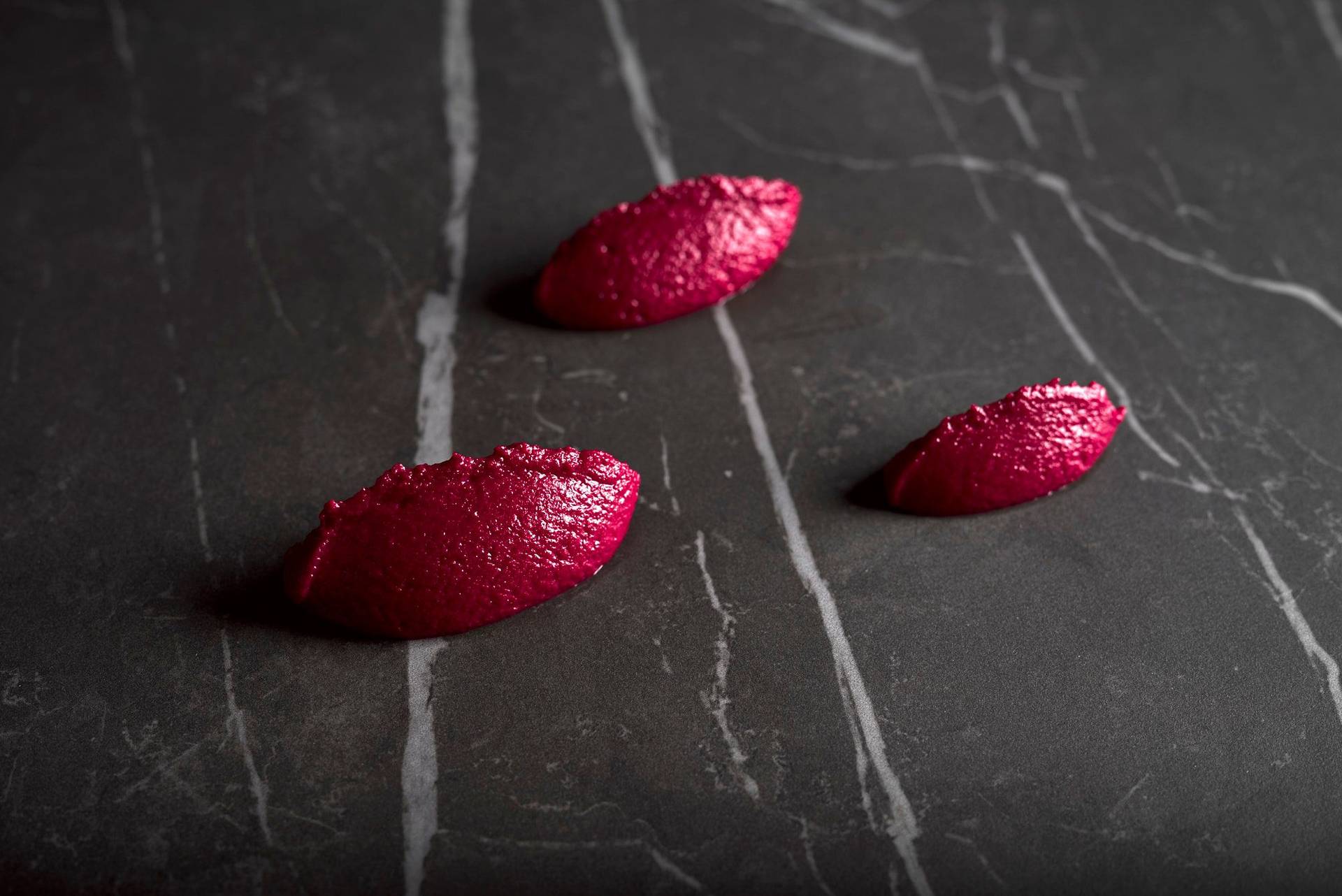 rote-beete-hummus drei löffel rote beete hummus auf grauem sapienstone top