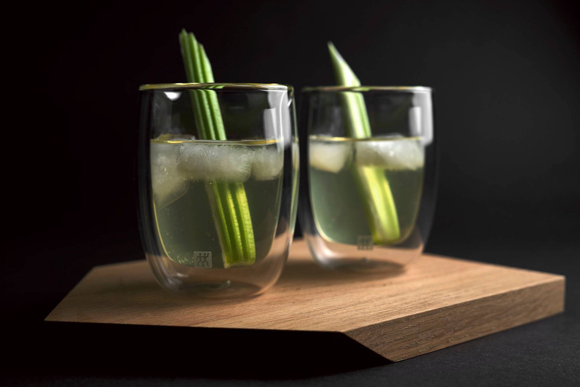 two glasses of white bloody mary on a wooden tray with black background