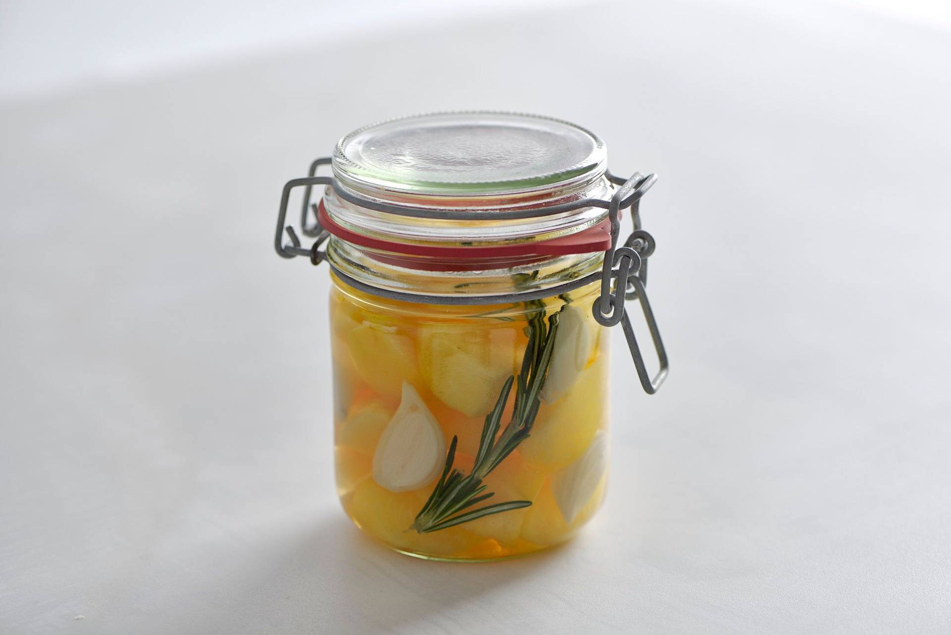plum pickles in a jar on a white sapienstone top