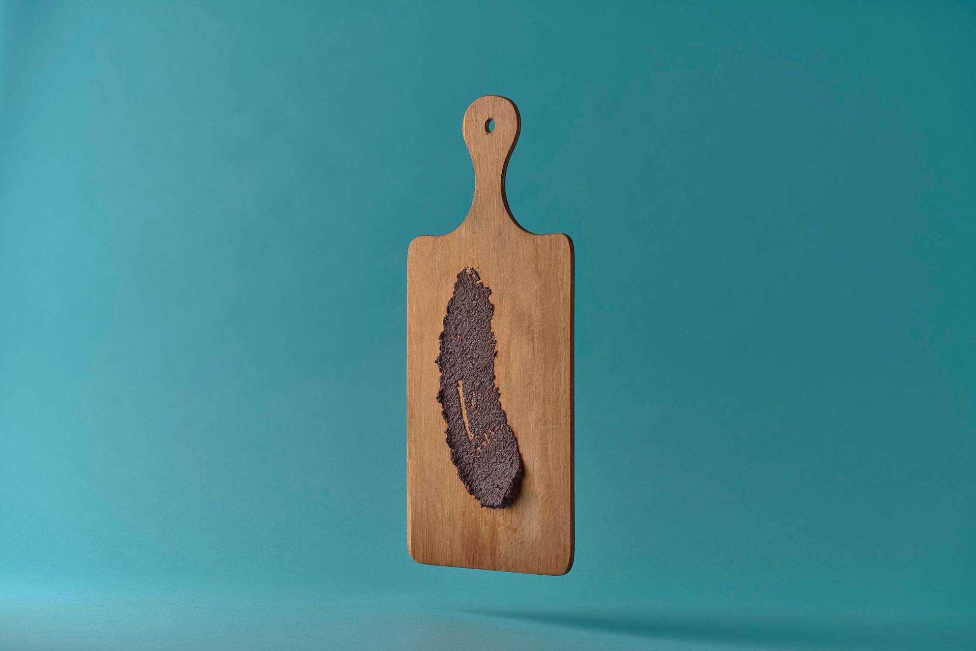 olive tapenade from pouli on a wooden board on blue background