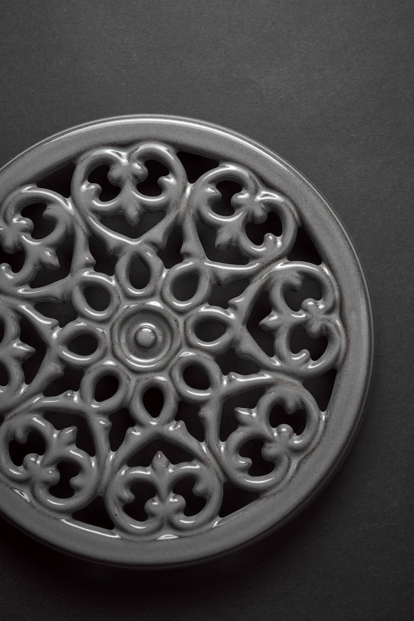 gray staub la cocotte cast iron coaster on black background