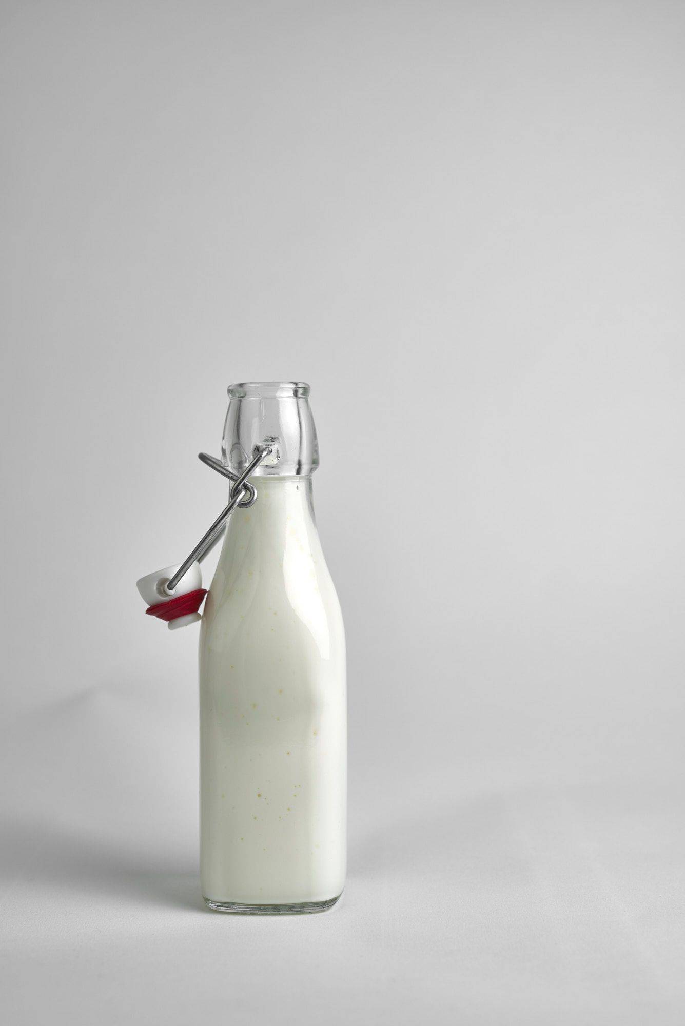 a small glass bottle of kefir on white background