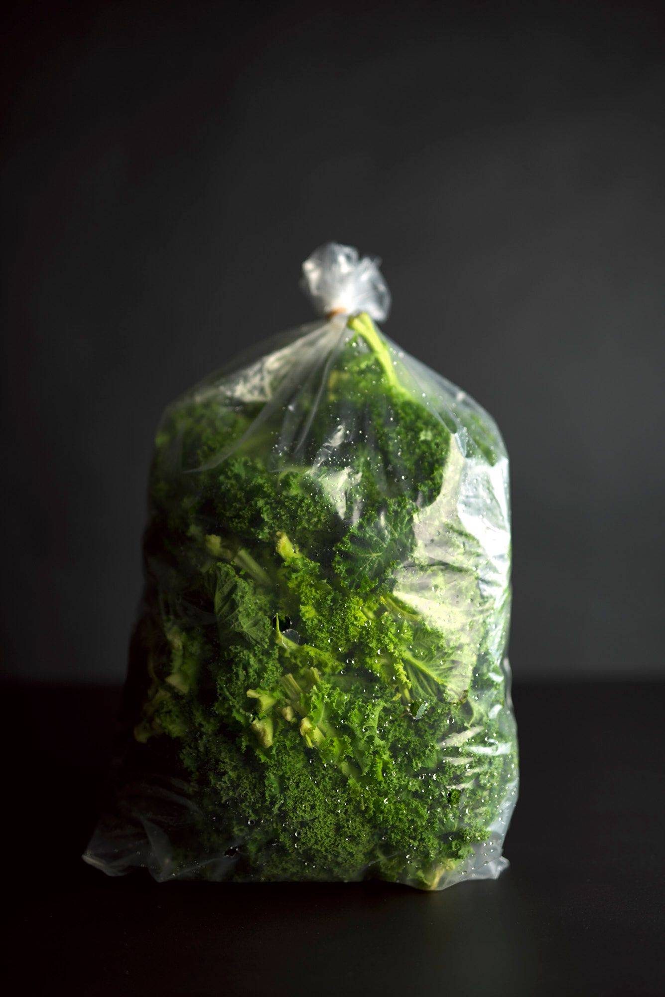 a bag of kale on black background