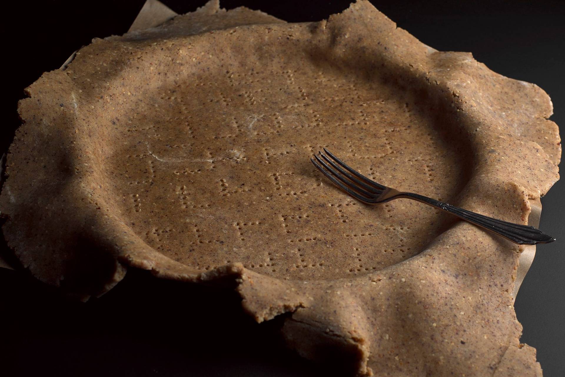 hazelnut sablé in a tart pan on black background