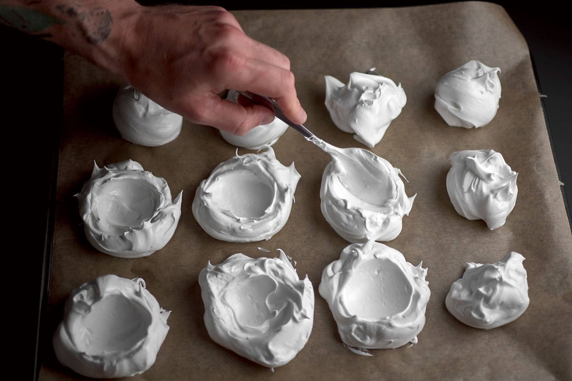 making pavlova meringue shells on a baking sheet