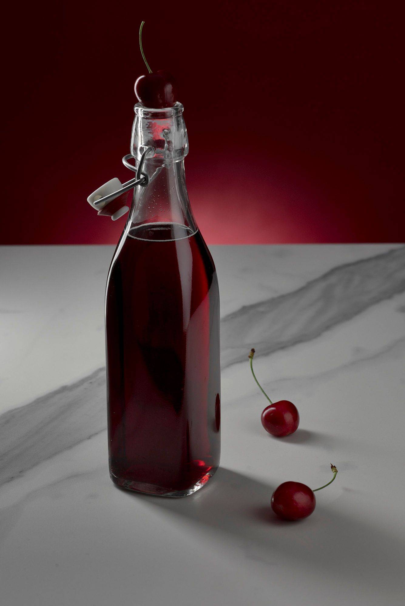cherry-and-rice-cooler-with-sake cherry and rice cooler with sake on marbled sapienstone top with red background