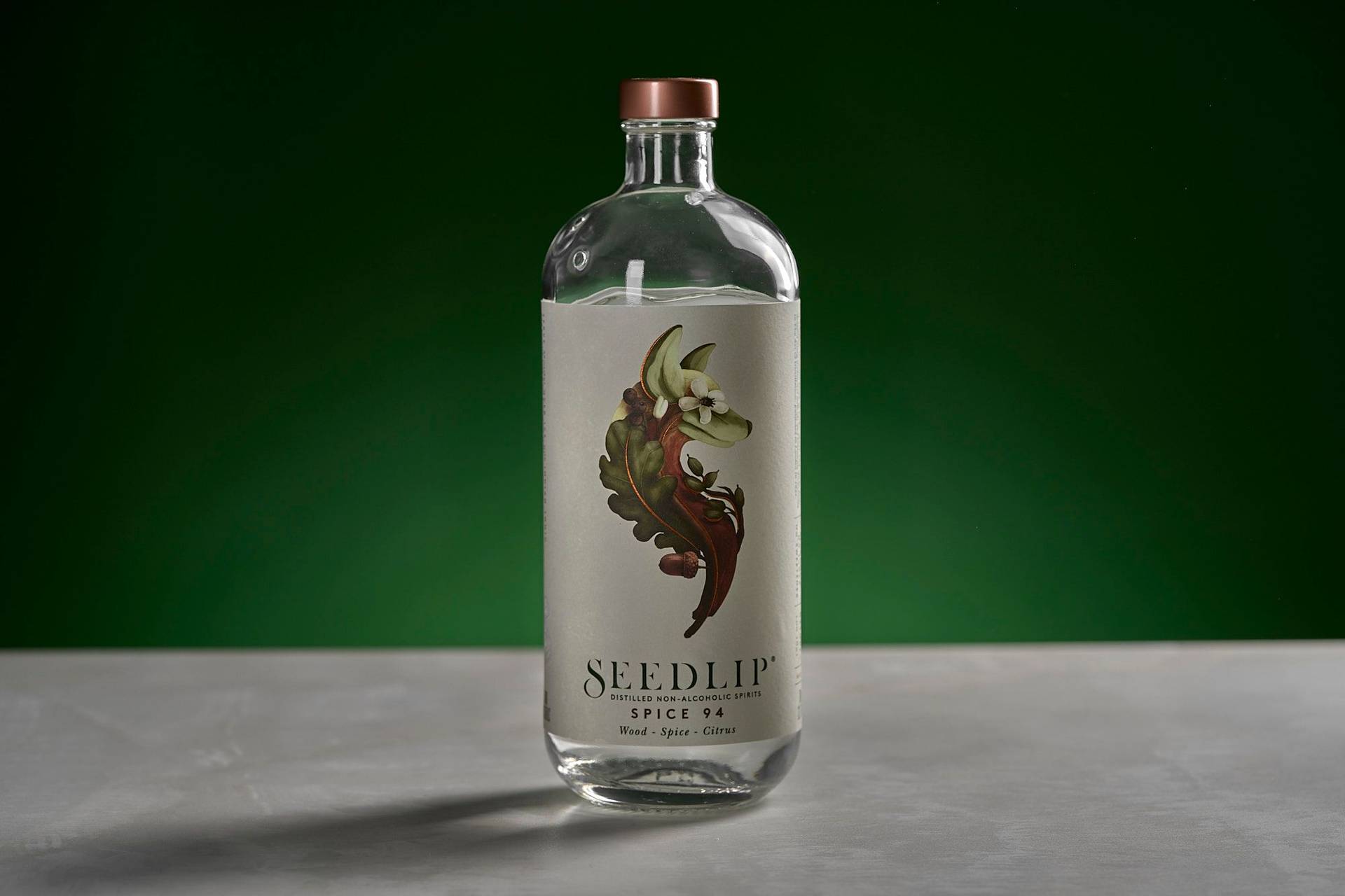 eine flasche alkoholfreies seedlip spice 94 auf weißem sapienstone top mit grünem hintergrund