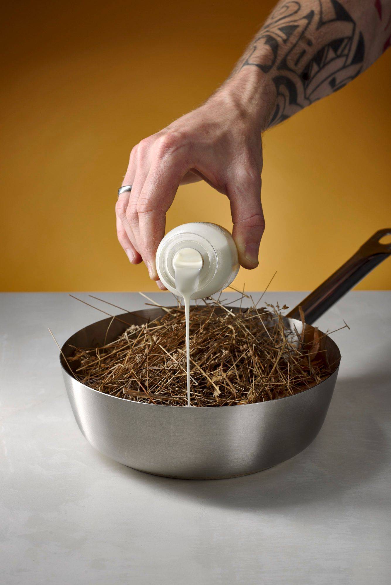 making hay sauce in a metal sauce pan with white sapienstone top and yellow background