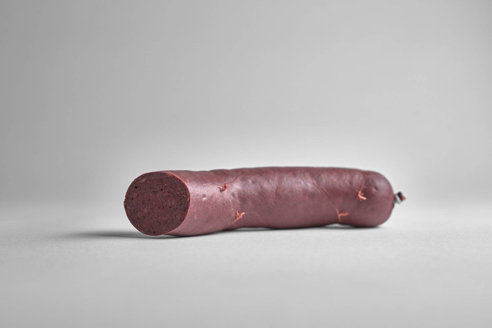 a sausage of boudin noir blood pudding on white background