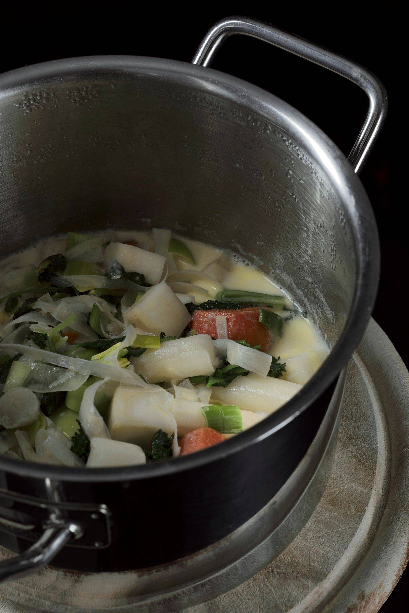 vegetable basil sauce in a metal pot with black background