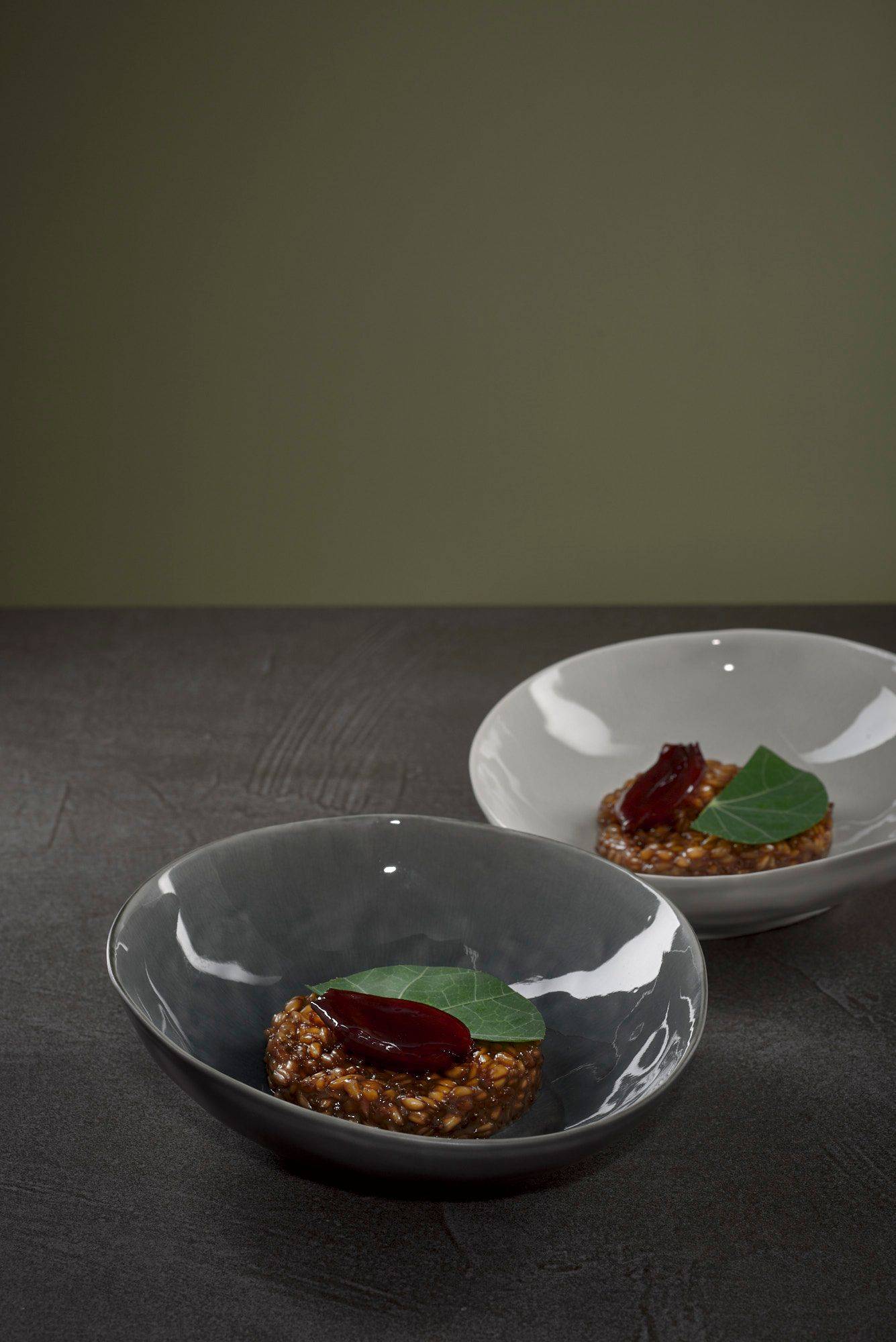 dinkel risotto mit harzer käse und rotwein schalotten auf grauem sapienstone top mit grünem hintergrund