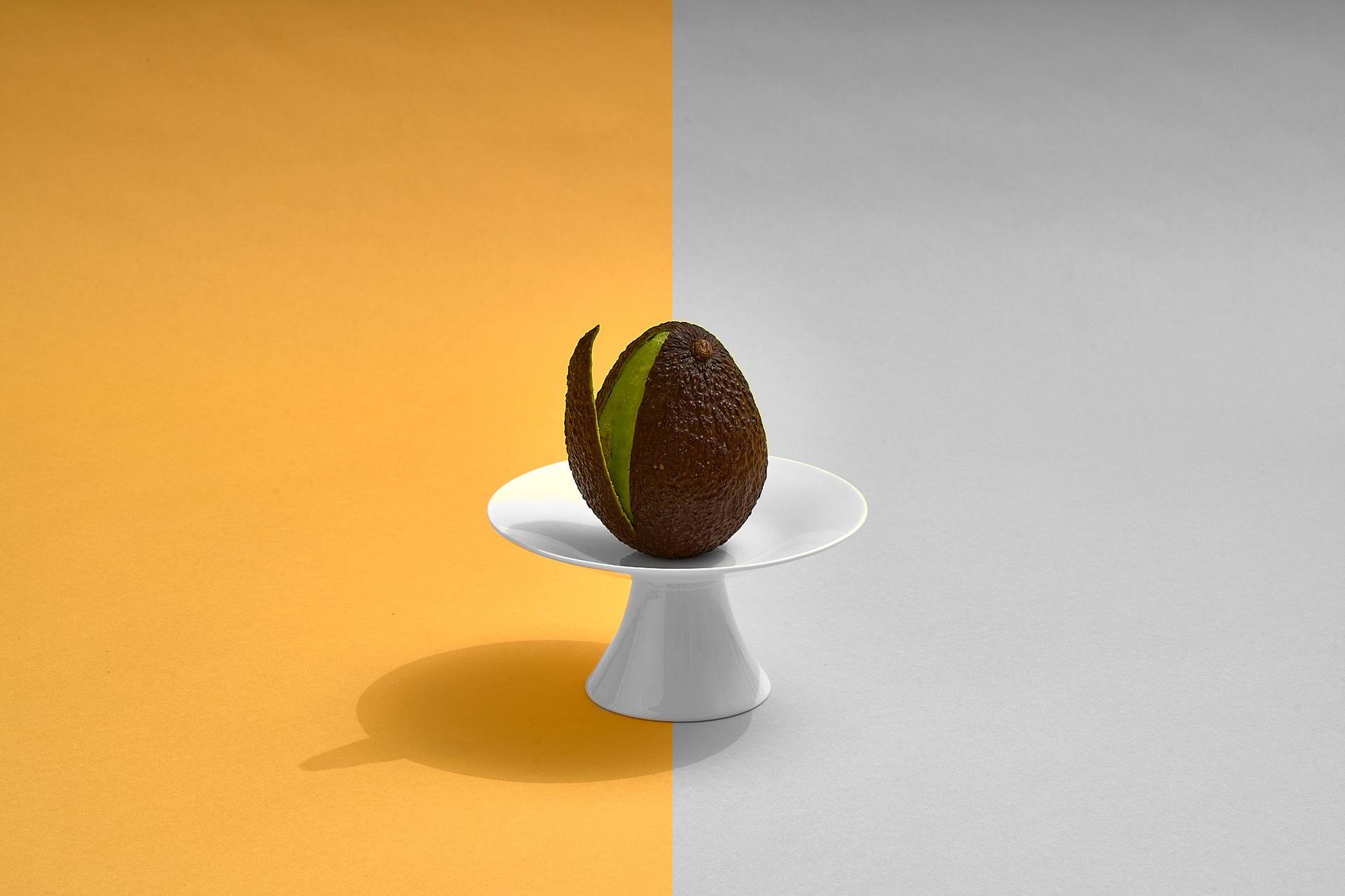 avocado on white plate on yellow background