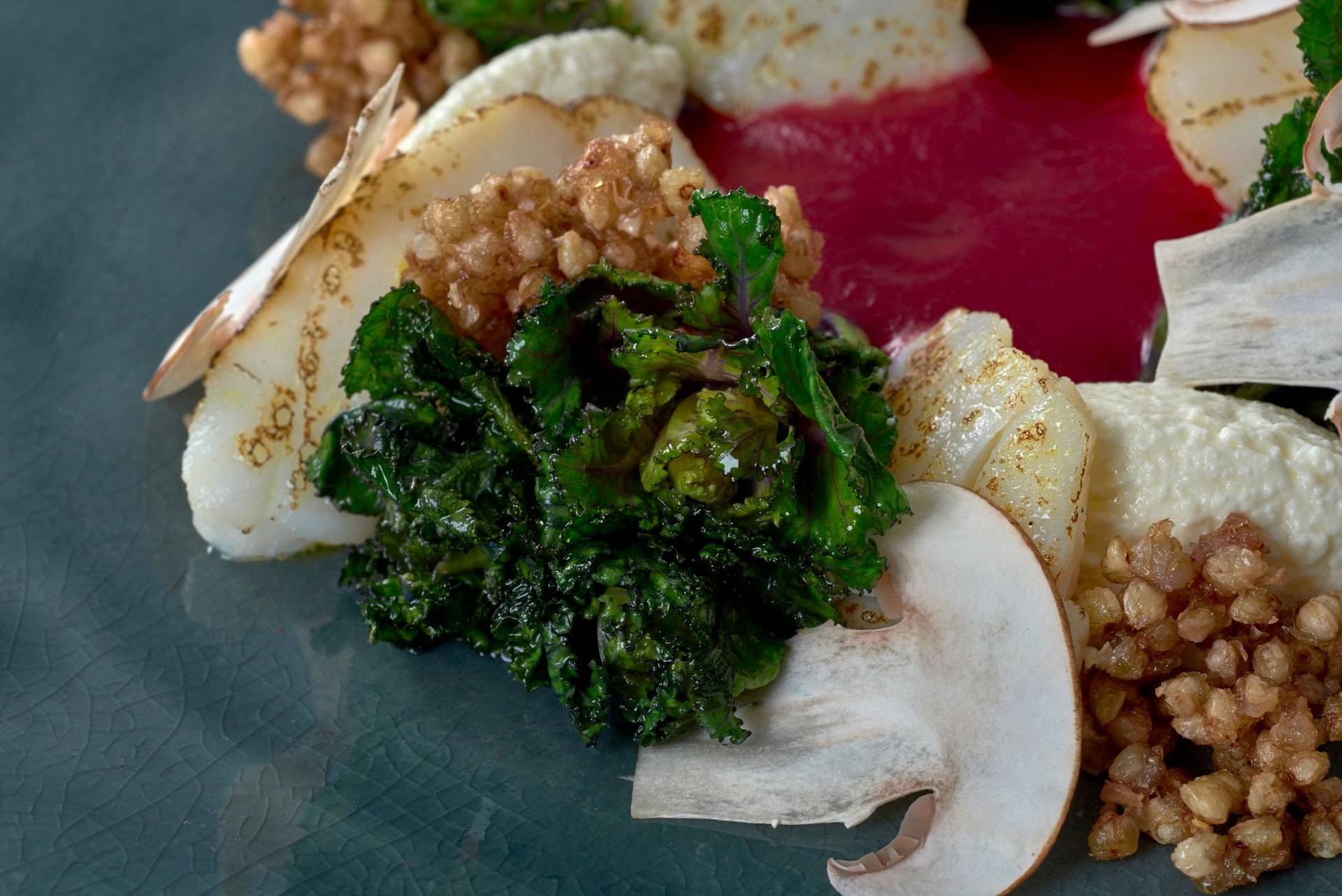 kabeljau mit roter beete ricotta molke und buchweizenpops auf einem grauen teller